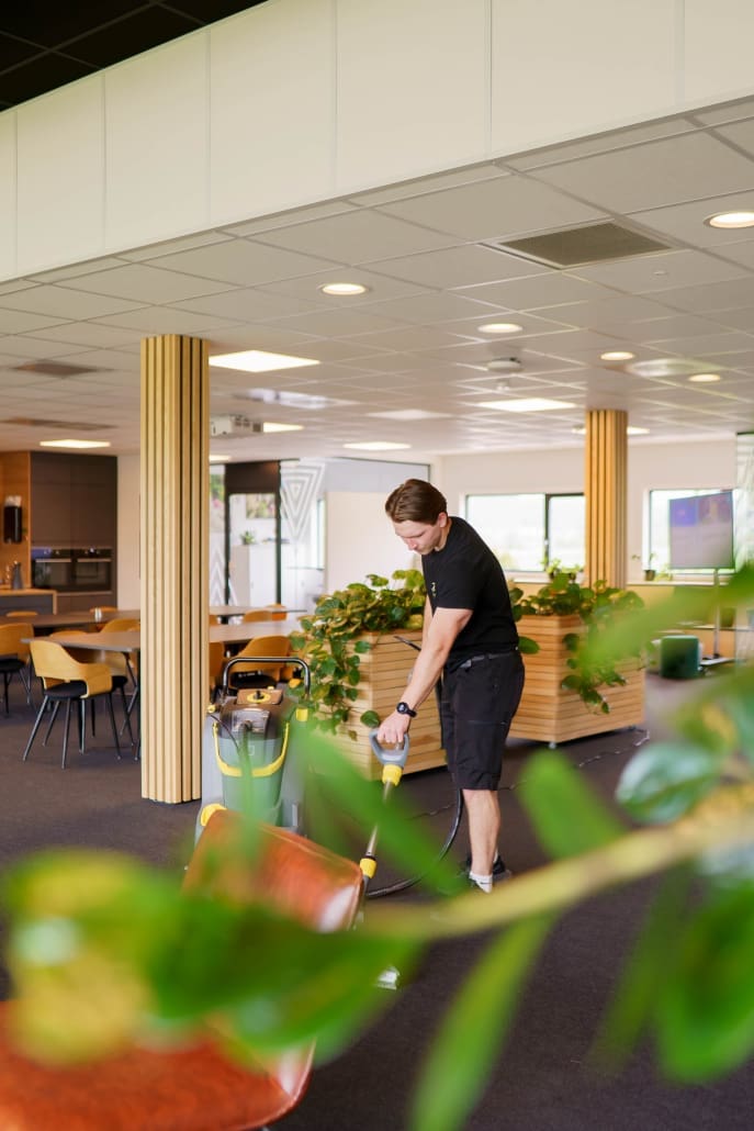 Profesjonell renholder fra Lotus Total renser tepper i kontorlokalet i Tønsberg